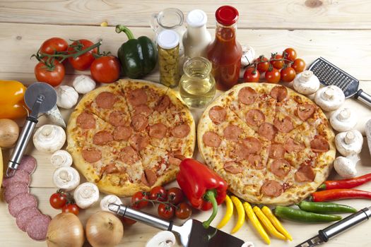 A couple of delicious pizzas, with raw tomatoes, green peppers and salami