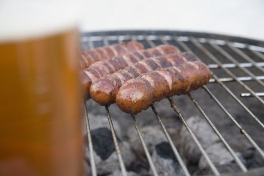 tasty sausages with beer on summer grill party