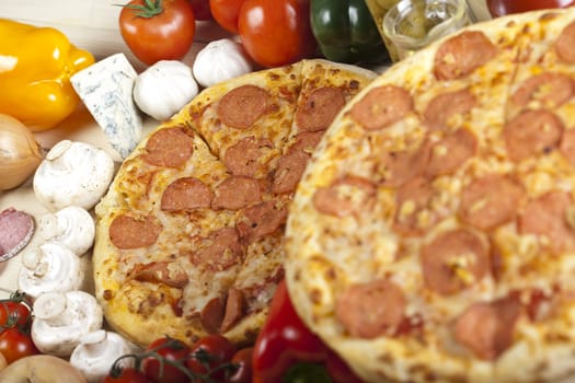 A couple of delicious pizzas, with raw tomatoes, green peppers and salami