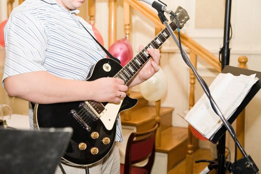 a man playing on his black guitar