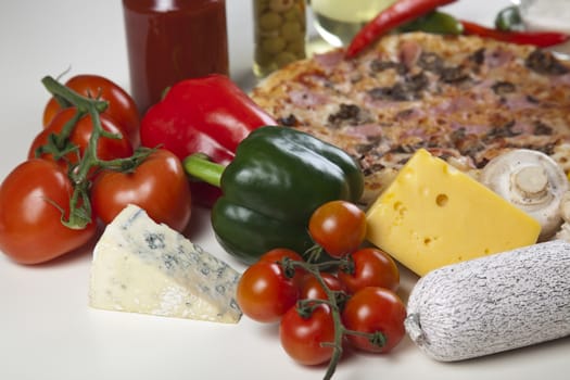 A couple of delicious pizzas, with raw tomatoes, green peppers and mushrooms