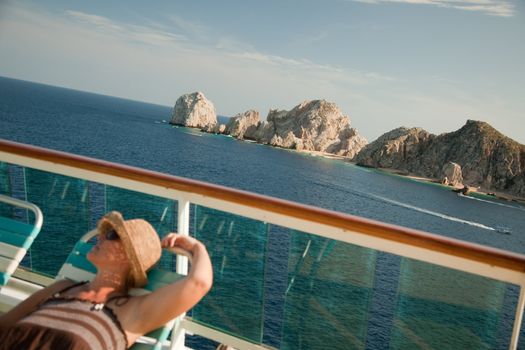 Beautiful Woman Relaxes on a Cruise Ship Deck at Land's End in Cabo San Lucas, Mexico.