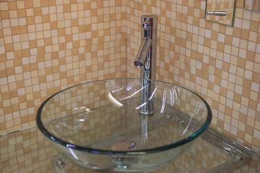 modern washbowl made of glass with silver tap