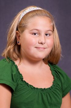 A nine year old girl sitting and getting his portrait done