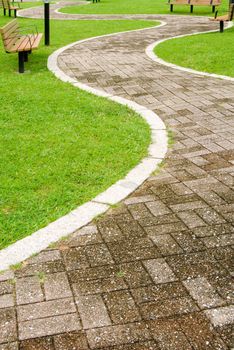 It is a cityscape of green park with curve way acrossed.