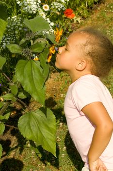Young Ethnic Girl smelling the flowers in the garden.
