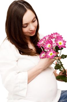 Beautiful pregnant woman holding belly with flowers