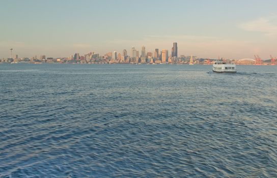 Seattle Skyline with Space Needle and Ferry as it crosses the waters of the Puget Sound as viewed from Alki.