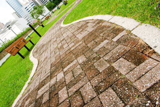 It is a cityscape of green park with curve way acrossed.