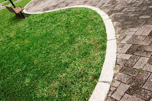 It is a cityscape of green park with curve way acrossed.