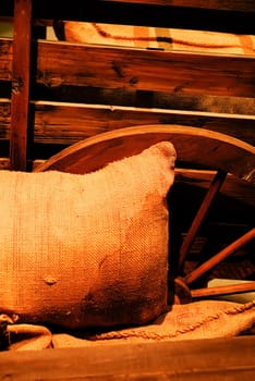 It is a bag of goods lay against the wooden wheel.