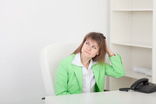 The young beautiful girl at office on a workplace