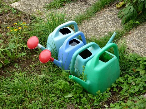 Four watering canes in garden green grass