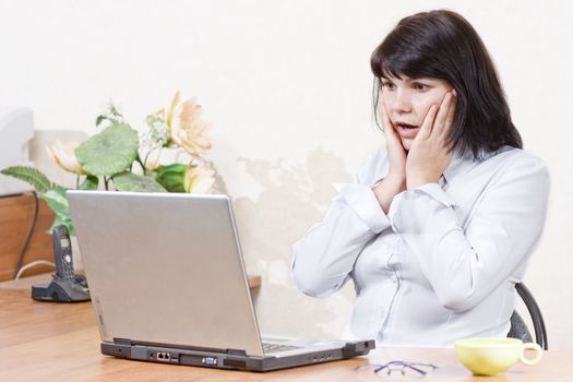 Surprised businesswoman in front of her laptop