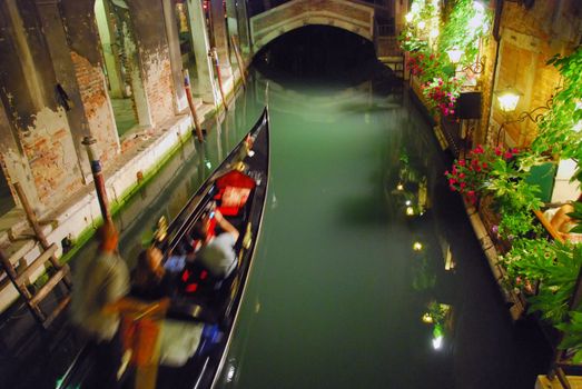 A Gondola in motion at night in a Venice canal