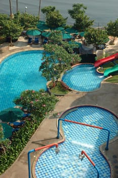 swimming pool surrounded by trees and plants in the summer
