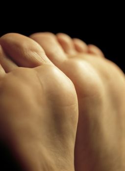 Very shallow depth-of-field image of the bottom of a females feet - possibly waiting for a massage.
