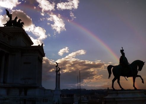 vittoriano's statues in rome with rainbow and cloudy sky