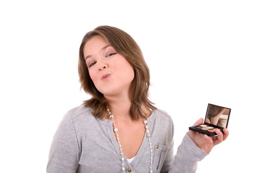 Cute 13 year old checking her makeup in a hand mirror