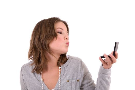 Pretty teenage girl checking her reflection in a little hand mirror