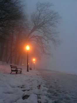 Bench and lighted lanterns in park