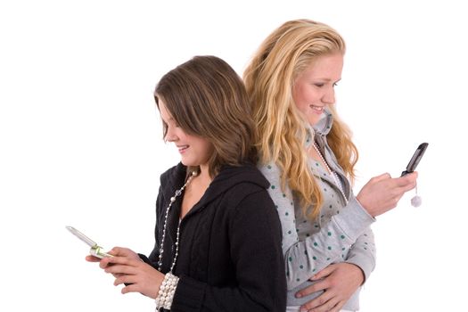 Two teenage girls standing side by side sending text messages