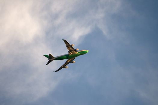 Soaring Jet Plane just after taking off from SeaTac Airport in Seattle Washington with a beautiful cloudy blue sky as a background.
