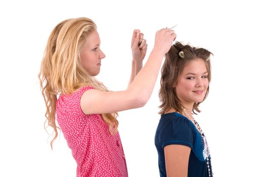 Two teenage girls doing each others hair