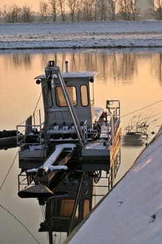 Cleaning boat on lake in winter