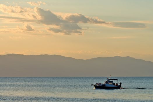 Moving boat on sea at sunset