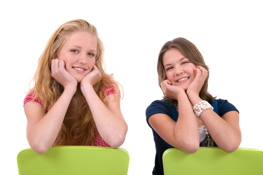 Two cute young girls leaning on their chairs