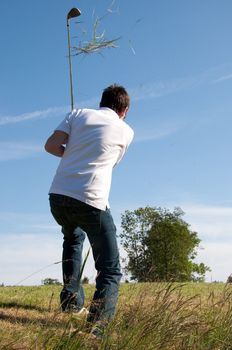 Male golfer hitting out off thick rough
