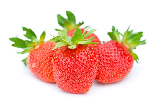 four ripe strawberries, selective focus, isolated on white