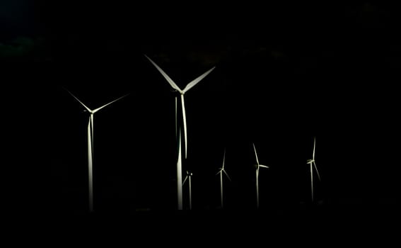 Alternative Energy Wind Power Turbines isolated against a black background.