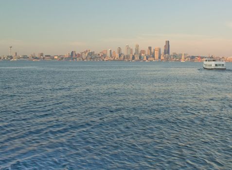 Seattle Skyline with Space Needle and Ferry as it crosses the waters of the Puget Sound as viewed from Alki.