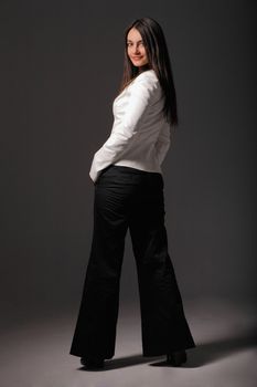 Attractive businesswoman posing with her hands in one's pockets posing