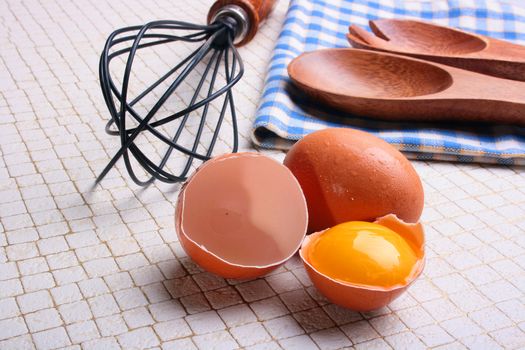 One of components of culinary recipes - the eggs, one of eggs is split and in a shell there is a yolk.