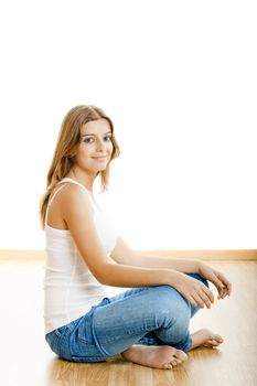 Portrait of a sexy young woman sitting on floor isolated over white background