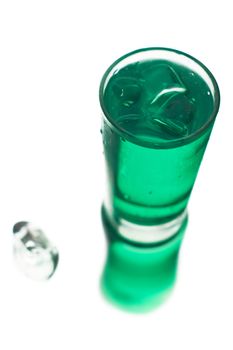 Frosty green coctail with ice in a glass on a white background