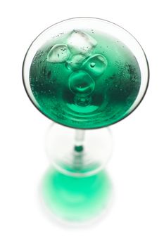 Frosty green martini with ice in a glass on a white background