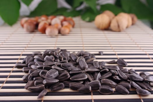 Seeds of sunflower and nuts on a striped bamboo napkin removed close up