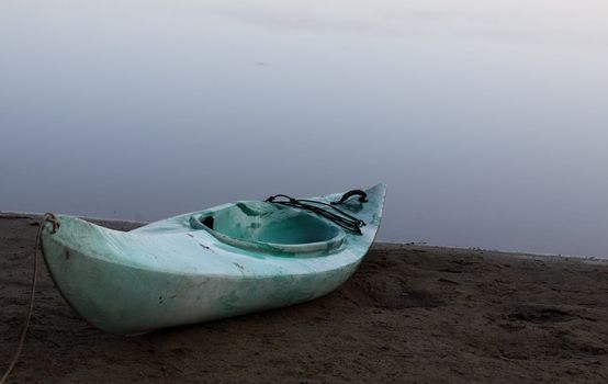 A kayak on the shore with Pog Lake in the background, shot in Algonquin Park, Ontario, Canada.
