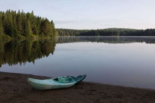 The reflection of evergreen trees in Pog Lake, in Algonquin Park, Ontario, Canada.
