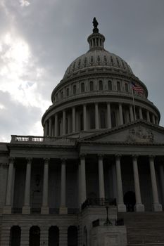 The front of the United States Capitol building, in Washington D.C., against stormy cloud.
