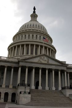 The front of the United States Capitol building, in Washington D.C., against stormy cloud.

