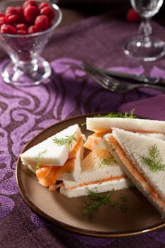 Delicious sandwiches with salmon and creamcheese stacked on a plate