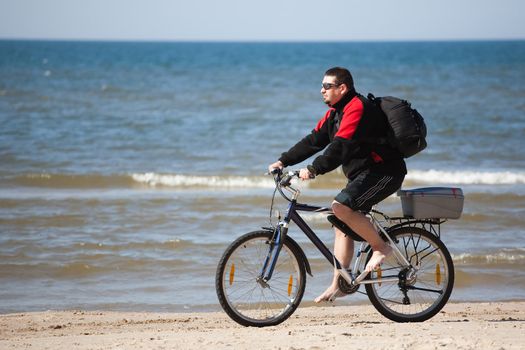 man riding mountain bike on the beach