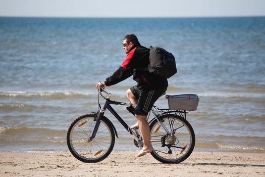 man riding mountain bike on the beach
