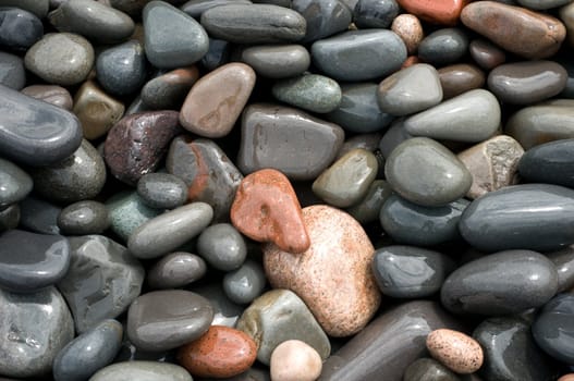 background wallpaper of  wet gray, black, and red granite stone pebbles