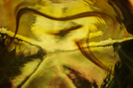 abstract background wallpaper of light refracted through yellow swirled glass